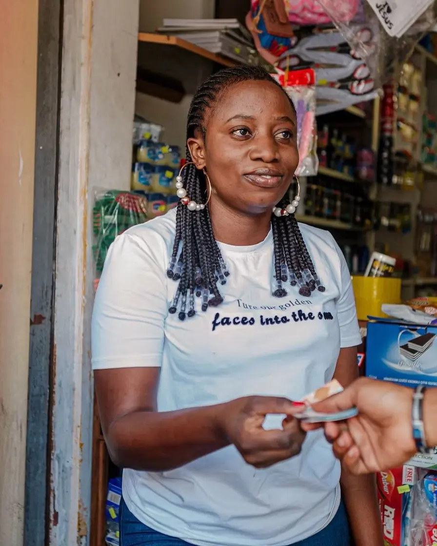 A shopkeeper serving a customer at the counter of a neighbourhood store